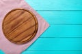 Brown round pizza cutting board on polka dots tablecloth. Blue wooden background in the restaurant. copy space, mock up Royalty Free Stock Photo