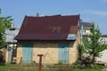 A brown rural brick shed with a metal roof and two blue doors Royalty Free Stock Photo