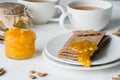 Brown rye crisp bread Swedish crackers with spread orange jam and cups of tea Royalty Free Stock Photo