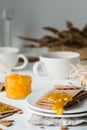 Brown rye crisp bread Swedish crackers with spread orange jam and cups of tea Royalty Free Stock Photo