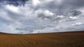 Brown sandy land under the dark cloudy grey sky