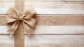 Brown satin ribbon bow on white wooden background with copy space. Generative AI