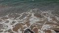 Brown sea water on the rocks beach in Full HD video 12p fps