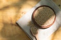 Brown sesame seeds in a clay bowl on a wooden table. Royalty Free Stock Photo