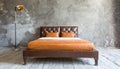 Brown shabby leather bed against concrete wall. Loft interior design of modern bedroom Royalty Free Stock Photo