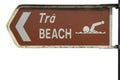 Brown sign beach in English and Irish language and pointing arrow.