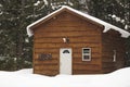 Brown snow covered cabin in field of pristine snow Royalty Free Stock Photo