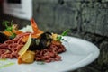 Brown spaghetti with seafood and herbs on a plate in a restaurant. Healthy diet lunch Royalty Free Stock Photo