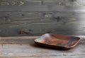 Brown square flat wooden empty plate on the texutred natural table made from timber. Normal angle. Horizontal with copy Royalty Free Stock Photo