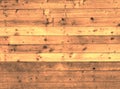 Brown stained old rustic wooden plank wall or floor with some of the boards made of reused timber