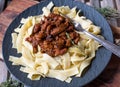 Brown stew chicken with tagliatelle on a plate. Italian cuisine Royalty Free Stock Photo