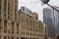 The brown stone Chicago Tribune building surrounded by glass skyscrapers and hotels in the city skyline on a cloudy autumn day