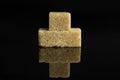 Brown sugar cube isolated on black glass Royalty Free Stock Photo