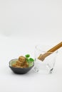 Brown sugar cubes on a blue plate woman hand hold a wooden tweezers a sugar cube in a glass cup on white background Royalty Free Stock Photo