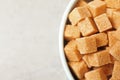 Brown sugar cubes in bowl on light grey table, top view. Space for text Royalty Free Stock Photo