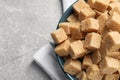 Brown sugar cubes in bowl on light grey table, top view. Space for text Royalty Free Stock Photo