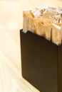 Brown sugar sachets in black box on a counter at a cafe