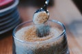 Brown sugar in spoon and dishware on napkin