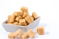 Brown sugar in a Square cup on a white background, healthy sugar is used for cooking or desserts