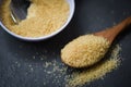 Brown sugar in wooden spoon on dark black background with cane sugar on white bowl Royalty Free Stock Photo