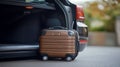 Brown Suitcase with Wheels by Open Car Trunk Royalty Free Stock Photo