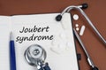 On a brown surface lie pills, a pen, a stethoscope and a notebook with the inscription - Joubert syndrome Royalty Free Stock Photo