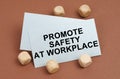 On a brown surface, wooden cubes and a business card with the inscription - Promote Safety at Workplace Royalty Free Stock Photo