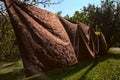 Brown tableclothes left to dry moved by the wind on a clear summer day Royalty Free Stock Photo