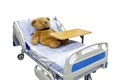 Brown teddy bear lying sick in bed with overbed table on body Royalty Free Stock Photo