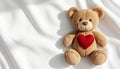 Brown Teddy Bear with Red Heart Lying on Fluffy White Towel Background Royalty Free Stock Photo