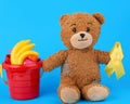 brown teddy bear sits and holds in his paw a yellow silk ribbon Royalty Free Stock Photo