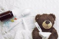 Brown teddy bear with a thermometer tablets and a medical mask Royalty Free Stock Photo