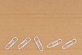 Brown textured cardboard with paperclips closeup background Royalty Free Stock Photo