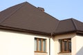 Brown Tiled roof of the house with windows on a background of blue sky Royalty Free Stock Photo