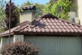Brown tiled roof of a private house with a gray concrete chimney Royalty Free Stock Photo