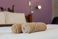 brown towels rolls on bed sheet in the hotel