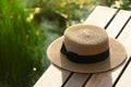 Brown traveling woman hat on wood terrace with outdoor lake view sunlight nature background