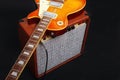 Brown tube combo amplifier for guitar with honey sunburst guitar on black background Royalty Free Stock Photo