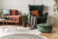 Brown velvet corner sofa and emerald green wing back chair in living room Royalty Free Stock Photo