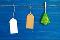 Brown and white blank paper price tags or labels set and Christmas felt decoration hanging on a rope on the blue background Royalty Free Stock Photo
