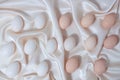 Brown and white chicken eggs lie on beige silk fabric