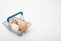 Brown and white chicken eggs in a shopping basket isolated on a white background