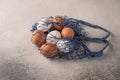 Brown and white chicken eggs in string bag on a light textured background. Copy space Royalty Free Stock Photo