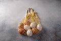 Brown and white chicken eggs in string bag on a light textured background. Copy space Royalty Free Stock Photo