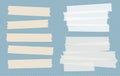 Brown and white different size adhesive, sticky, masking, duct tape, paper pieces on blue squared background. Royalty Free Stock Photo