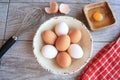 Brown and white eggs in white bowl and wisk