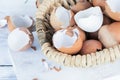 Brown and white eggshells placed in basket on white table, natural calcium source Royalty Free Stock Photo