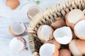 Brown and white eggshells placed in basket on white table, natural calcium source Royalty Free Stock Photo