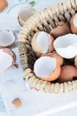 Brown and white eggshells placed in basket on white table, natural calcium source Royalty Free Stock Photo