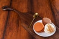 Brown and white french macarons or macaroons in a plate on a chopping board with golden teaspoon over vintage wood background Royalty Free Stock Photo